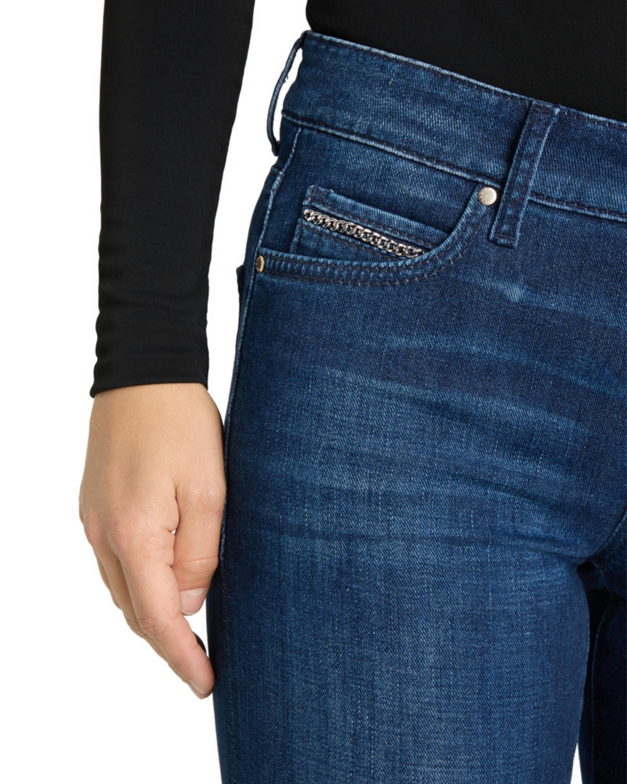 Cambio Paris Flared jeans i mørk blå denim med sølvfarget kjede i liten myntlomme, damehånd med sorte ermer