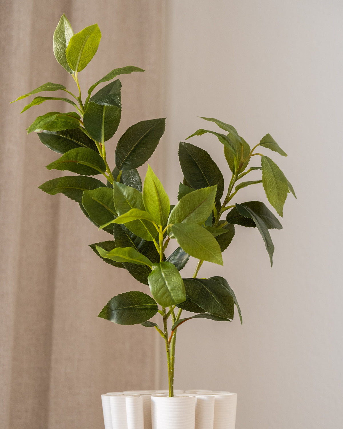 Amarante Osmanthus kunstig blomst med naturtro grønne blader, detalj av struktur i hvitt rillepotte.