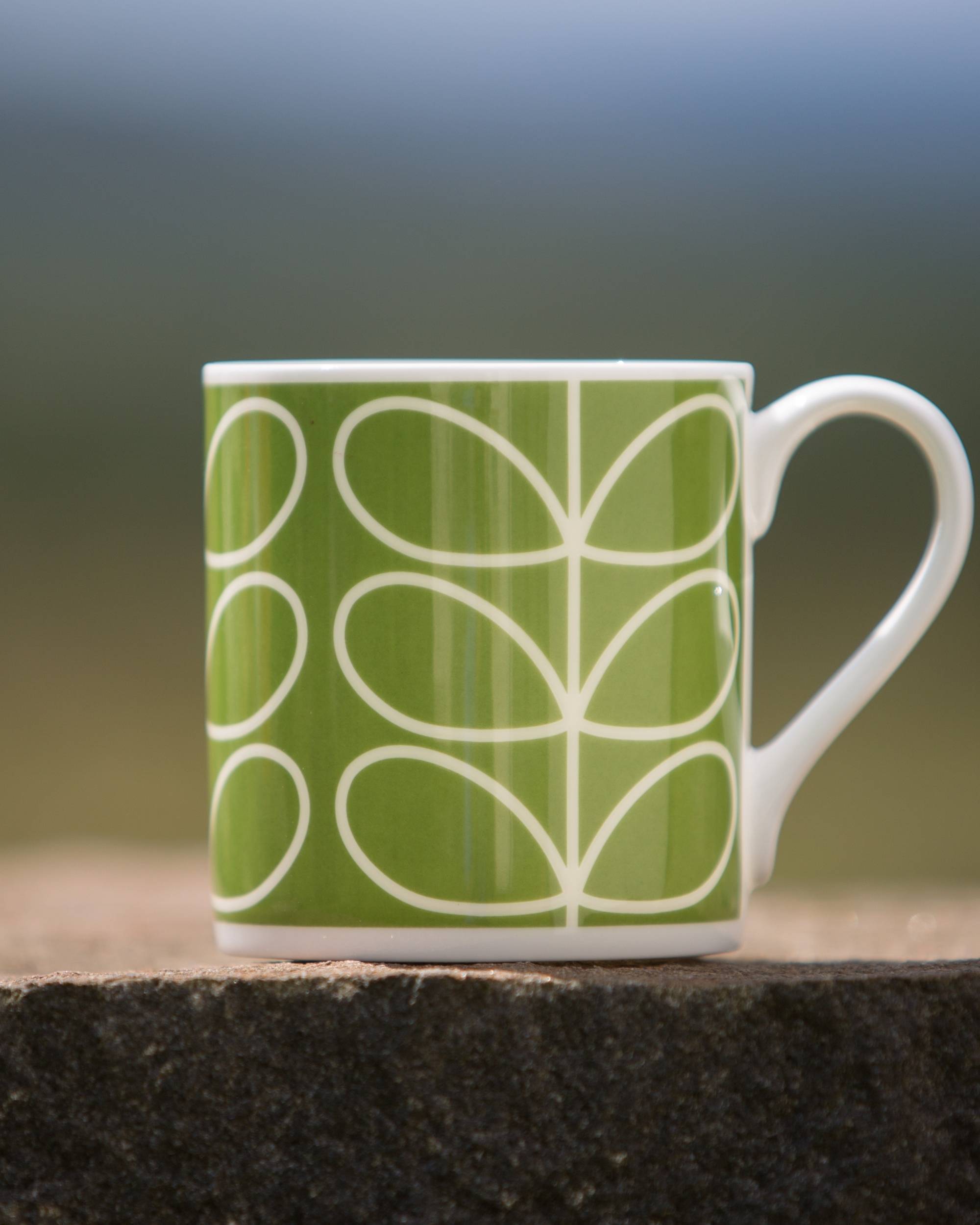 Orla Kiely Linear Stem Green kopp, lys grønn keramikk med hvitt grafisk bladmønster, hvit hank