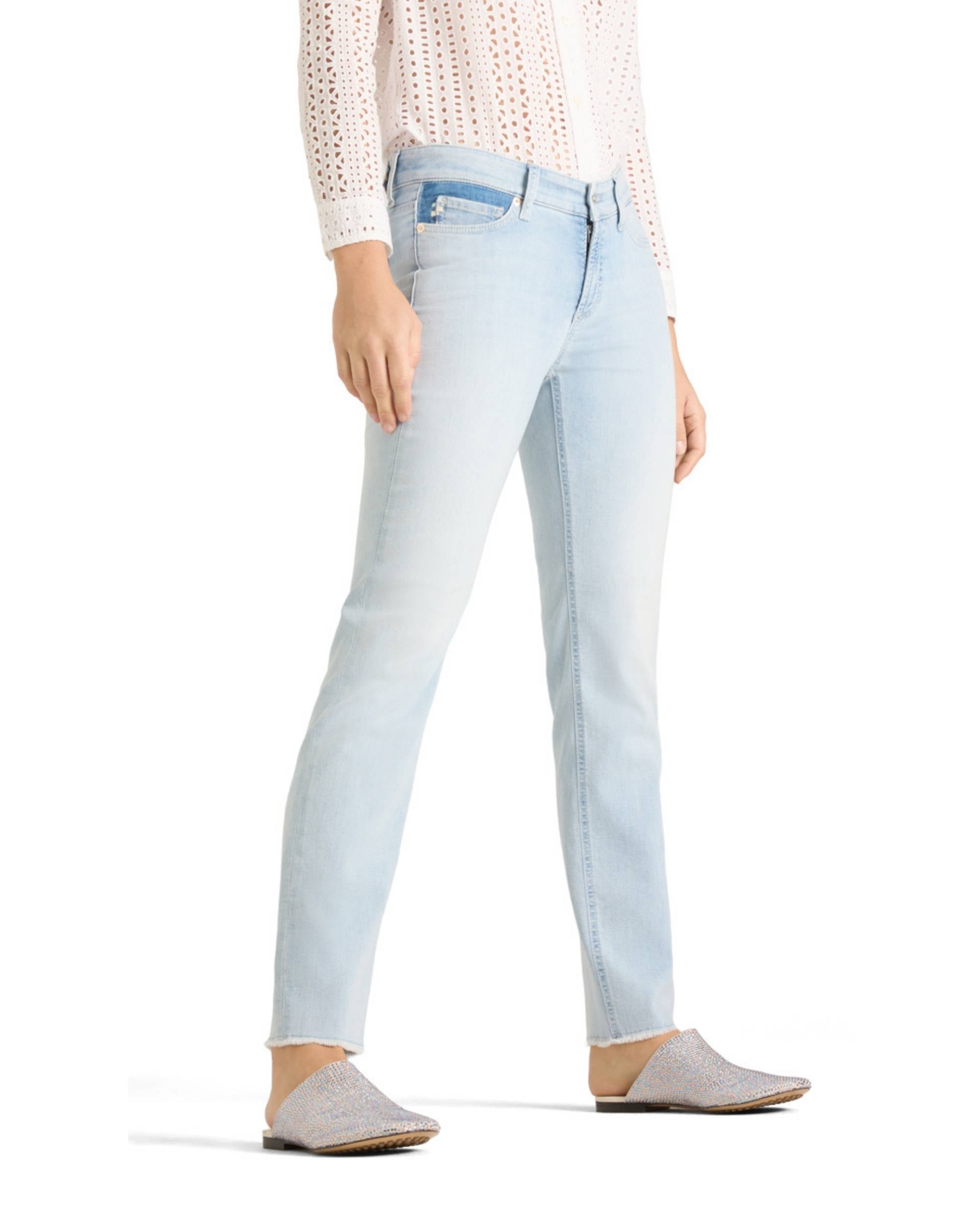 Detaljbilde av Cambio Piper Cropped Fringed jeans i lyseblått denim, med rå kant nederst på bena.